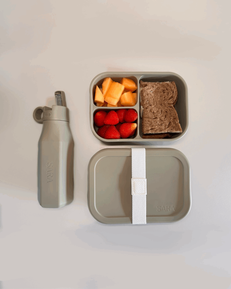 siliconen lunchbox en drinkfles set met inhoud, boterham en fruit zichtbaar