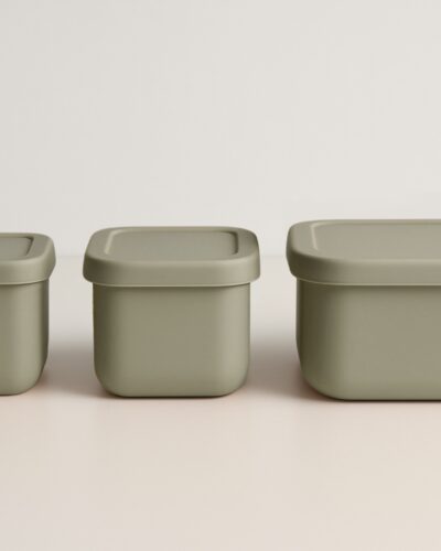 Drie stone green snackdoosjes in een rechte lijn naast elkaar, deksels gesloten