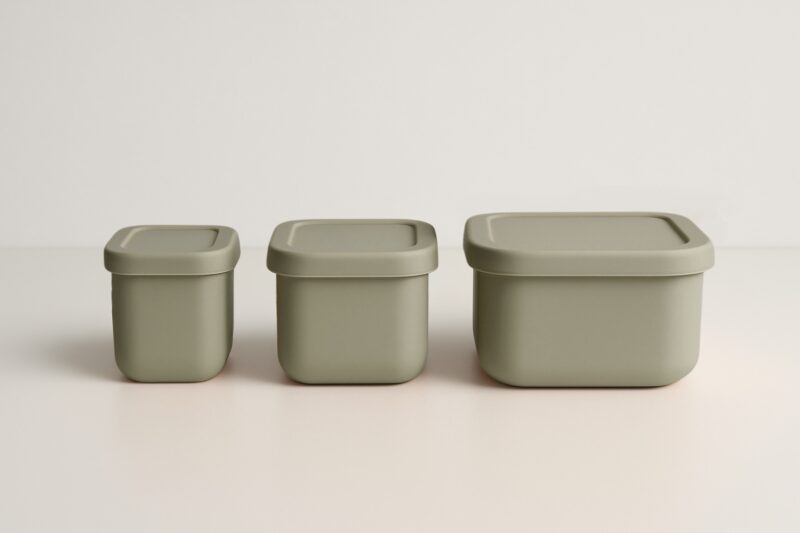 Drie stone green snackdoosjes in een rechte lijn naast elkaar, deksels gesloten