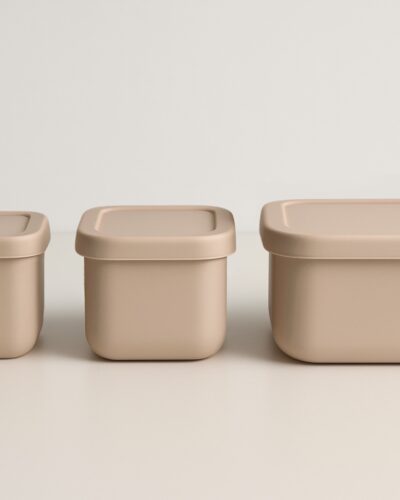 Drie beige snackdoosjes in een rechte lijn naast elkaar, deksels gesloten