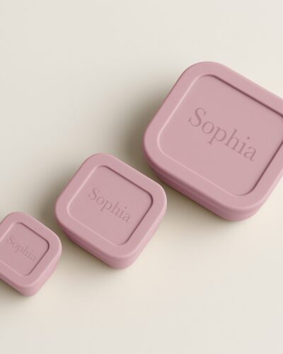 Bovenaanzicht van pale pink snackdoosjes met naam gegraveerd op de deksel